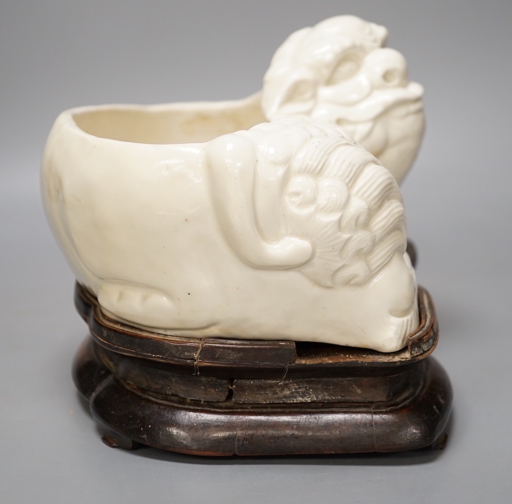 A Chinese cream glazed lion’dog planter on hardwood stand, 21cm